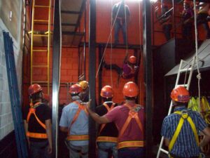 Funcionário equipado com cinto de segurança em treinamento de NR 35 para trabalho em altura