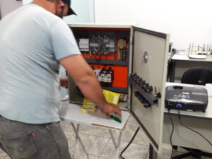 Eletricista durante treinamento prático de segurança em instalações elétricas NR 10 em simulador